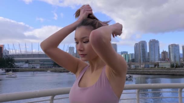 Young Asian Woman Puts Hair Ponytail Vancouver Cityscape Background — стоковое видео
