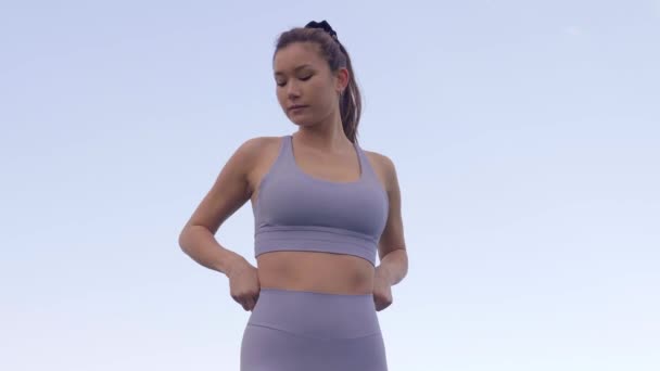 年轻女子调整运动胸罩和配套的腿 慢动作 — 图库视频影像