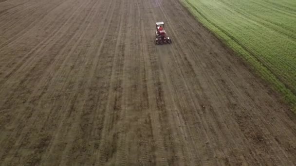 空中风景秀丽的农田景观 红色拖拉机驱动上坡犁耕 播种前用现代设备准备 — 图库视频影像