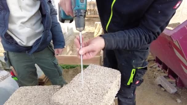 Man Drilling Long Screw Hempcrete Block — стоковое видео