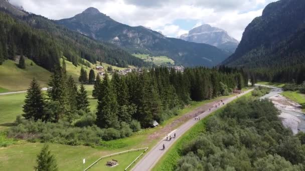 Val di Fassa (Fassa Valley) at Trentino, Dolomites, Italy - Aerial Drone View of Cycling Tourists and Green Mountain Valley