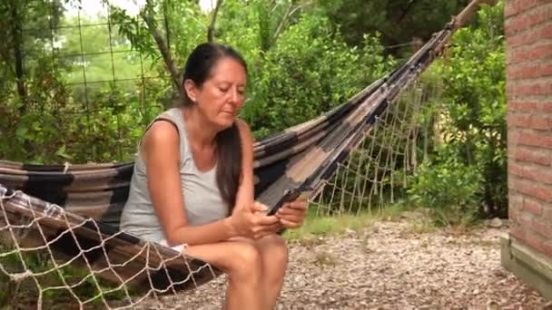 Middle Aged Woman Sitting Hammock Outdoor Dialled Called Someone Phone — Stockvideo