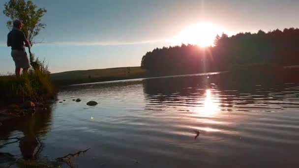 Mężczyzna Łapie Rybę Żywo Brzegu Pięknego Spokojnego Jeziora — Wideo stockowe