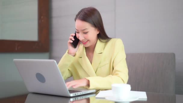 Businesswoman Her Smartphone One Hand While Working Her Laptop Other — Wideo stockowe