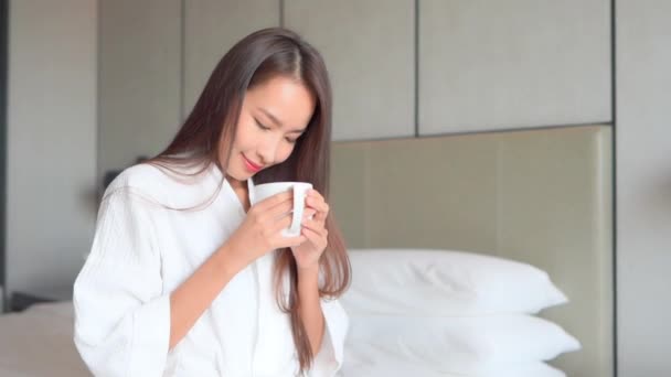 Mooie Aziatische Vrouw Badjas Met Kopje Hete Koffie Thee Bed — Stockvideo