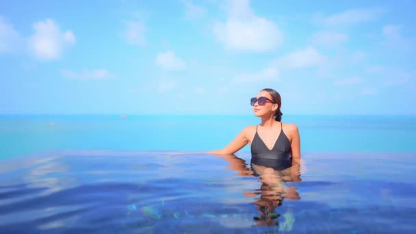 一位年轻迷人的女子在游泳池里举手调整太阳镜 标题空间 — 图库视频影像