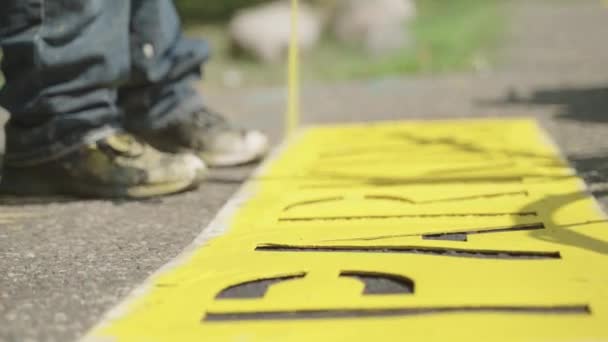 Construction Worker Spray Painting Parking Lot Road Sign Stencil Cutout — Stockvideo