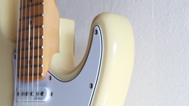 Beyaz Bir Duvardan Sarkan Krem Beyazı Bir Stratocaster Yakın Çekim — Stok video