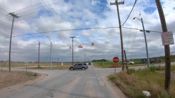 在德克萨斯州里约格朗德谷地的一条两车道的路上 Pov接近一个停车标志 开车经过几所房屋和菜地 — 图库视频影像
