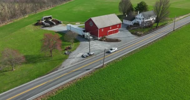 Paオランダアーミッシュ16進記号と白い農家と赤い納屋 農村部のアメリカで多くのビジネス 春の緑のフィールド 道路上の車のドライブ — ストック動画