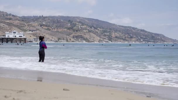 Woman Surfer Standing Edge Beach Looking Other Surfers — Video Stock