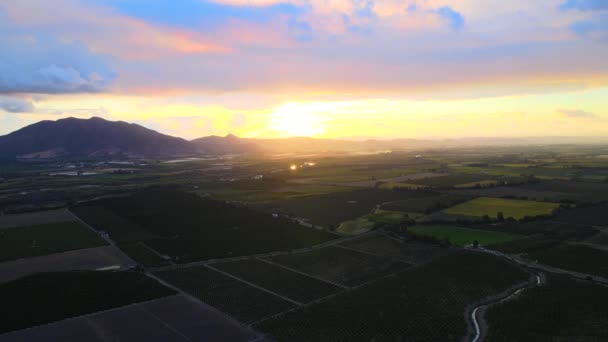 Pan Aéreo Derecha Campos Verdes Rodeados Montañas Una Nublada Puesta — Vídeo de stock