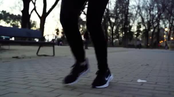 城市公园里穿着跑鞋慢跑的瘦腿女 近身跑 — 图库视频影像