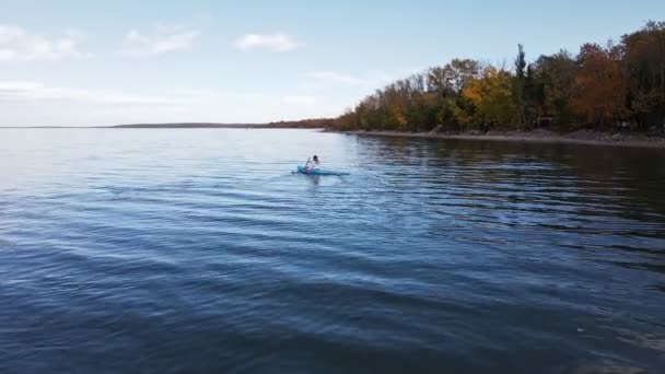 Γυναίκα Καγιάκ Μια Μεγάλη Μπλε Λίμνη Μπροστά Από Φθινόπωρο Φύλλωμα — Αρχείο Βίντεο