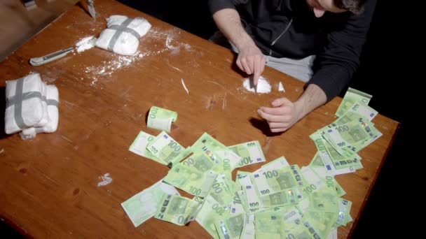 Drogový dealer s kokainem a bankovkami na stole. vysoký úhel