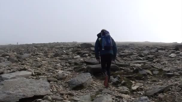威尔士斯诺多尼亚国家公园 一个背着背包在多雾多石的Glyder Fawr山顶上徒步旅行的人 — 图库视频影像