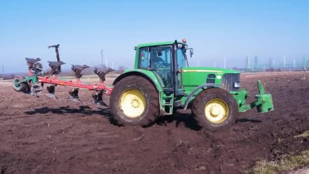 Green Farm Tractor Plows Dry Land Field Sunny Spring Day — Vídeos de Stock