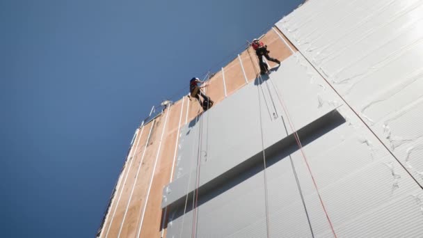 在蓝天的城市里 建筑工人们正在修理一个现代的立面 — 图库视频影像