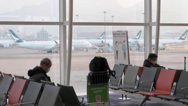 승객들은 앉아서 비행기에 탑승하기를 기다리고 있으며 퍼시픽 비행기들은 활주로에 — 비디오