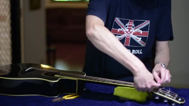美しい黒のシングルカットアウェイギターをリストリングし クリーニング スニップのペアを使用して ヘッドストックから弦の余分な長さを削除します — ストック動画