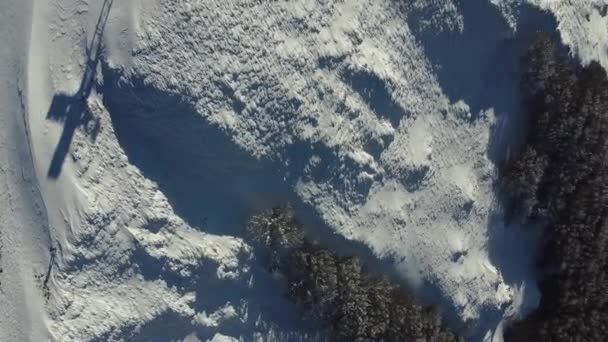 新鮮な白い雪の空中トップダウンは クリスチャンのクロスで山のピークをカバーし 冒険冬のアウトドアスキー活動をトレッキング — ストック動画