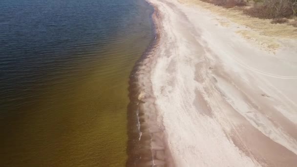 在阳光明媚的春天 海浪与白沙滩相撞的空中图像 波罗的海 拉脱维亚帕佩海滩 广角显示无人驾驶飞机向后向后飞去的镜头 — 图库视频影像