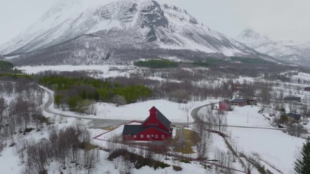 旧ノルウェーの冬の真ん中にある雪に覆われた山のふもとにあるKaafjord教会 Orbiting Airial Shot — ストック動画