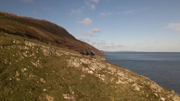 Drone Tiro Homem Sentado Grande Penhasco Marinho Irlanda Dia Ensolarado — Vídeo de Stock