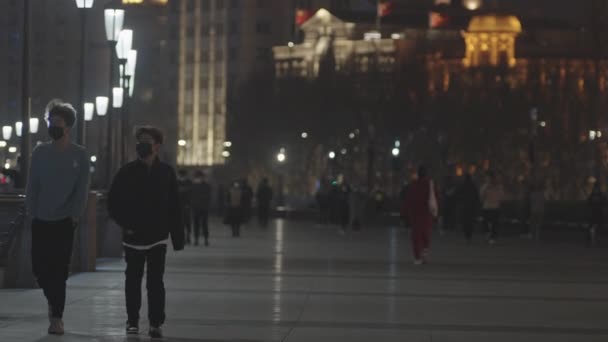 带着面具的人晚上在中国上海的外滩散步 Covid 19大流行病期间的生活 — 图库视频影像