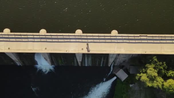 Aerial Top Shot Two People Walking Bridge Dam Dike Sunny — Vídeo de Stock