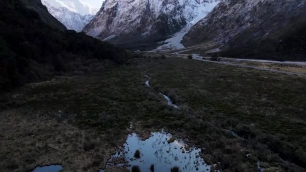 ニュージーランドの白いピークを持つ山の中で美しい渓谷の空中ドローンショット 雪に覆われた高い山の頂上 — ストック動画
