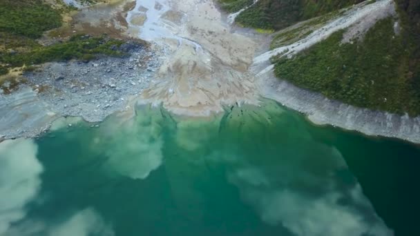 Aerial view of a diverging glacier water river in New Zealand, delta water entering a lake, colourful texture pattern in New Zealand. Top down drone view of water entering a river in the mountains.