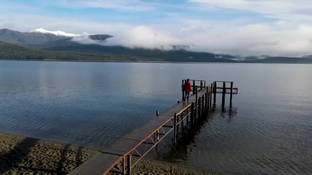 Man Loopt Een Houten Pier Bij Een Meer Een Bewolkte — Stockvideo