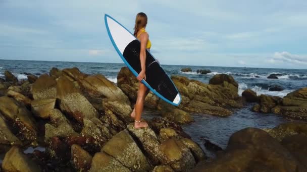 Atrakcyjne Bikini Kobieta Stojąca Skalistym Brzegu Trzyma Deskę Surfingową Widok — Wideo stockowe