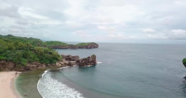 Aerial Flyover Coastline Pantai Cloudy Day Crashing Waves Rocks Shore — Stockvideo