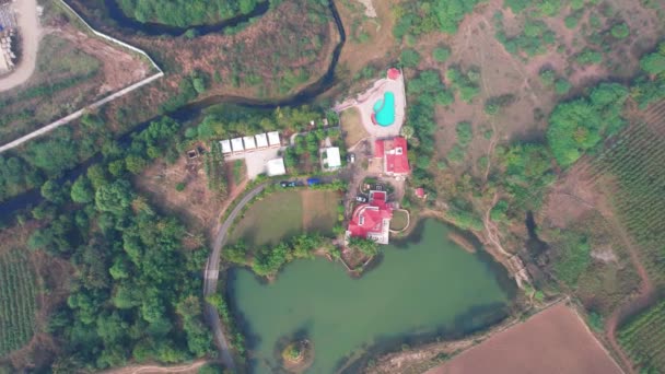 インドのVadodaraにある美しい湖とプールがある森とネイティブの植生に囲まれた豪華な白い休暇の家に向かって非常に高い空中ズーム ドローンで空中撮影しました — ストック動画