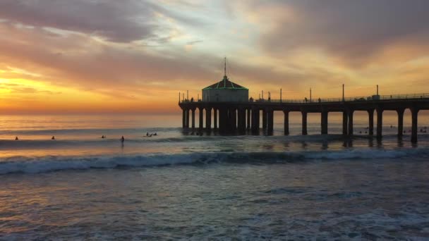 Mensen Surfen Onder Manhattan Beach Pier Bij Zonsondergang Met Een — Stockvideo