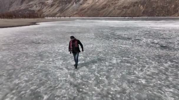 Adult Male Walking Frozen Khalti Lake Aerial Dolly Back — Vídeos de Stock