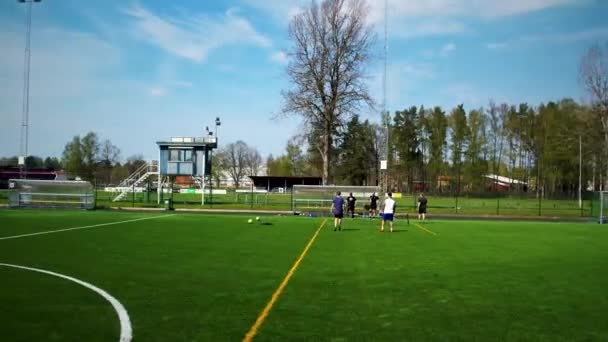 Drone flying by people playing football tennis in the Summer.