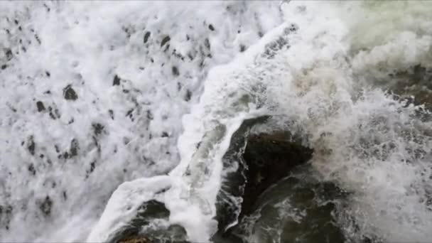 黑暗的大块岩石的特写被海里的白云海浪击中 — 图库视频影像