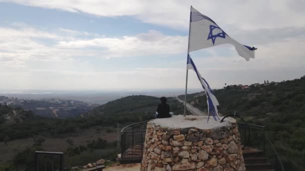 Plano Aéreo Del Hombre Sentado Cerca Del Israel Bandera Katzir — Vídeos de Stock