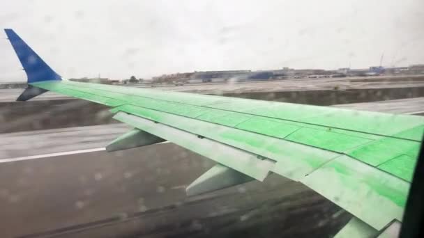 机翼上绿色除冰液体在雪中起飞的窗台Pov — 图库视频影像