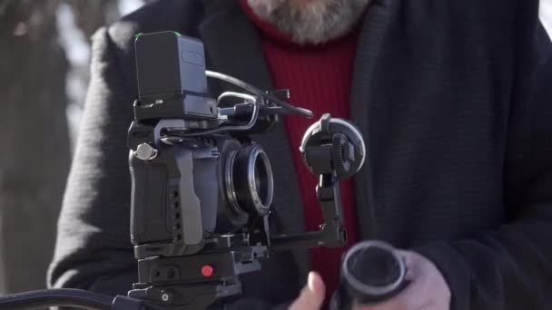 映画製作者はデジタルフィルムカメラのレンズを交換する クローズアップショット — ストック動画