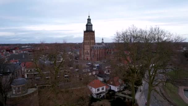 オランダのツッフェンにある冬の不毛の木の枝を通して見られるWalburgiskerkは 中央広場の周りの中世の屋根を持ちます 空中都市景観パン — ストック動画
