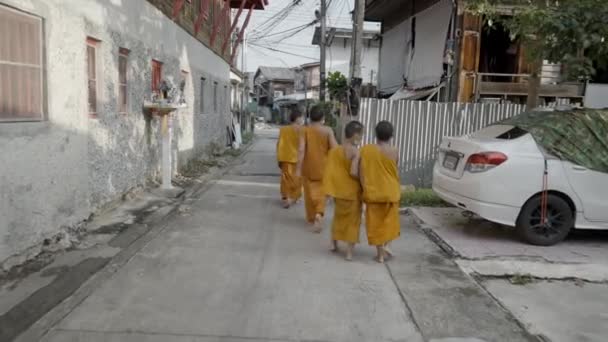 一群年轻僧人在农村地区沿街行走 回头看慢镜头 — 图库视频影像