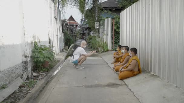 Hombre Caucásico Tomar Fotos Monjes Jóvenes Sentados Carretera Hormigón Una — Vídeo de stock