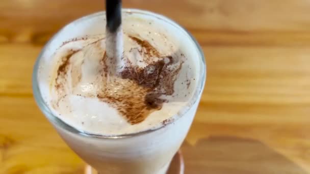 在木桌上搅拌奶油泡沫冰凉咖啡马奇亚托 — 图库视频影像