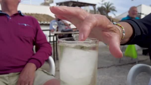 Person Pushing Ice Cube Glass Finger People Sitting Outdoors Spanish — Vídeo de Stock