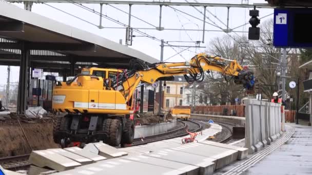 メンテナンス現場の労働者と重機械をその場所に大きなブロックを置くとゾッフェンの鉄道線路の建設作業 — ストック動画