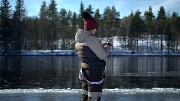 川の冬の風景 北部の自然活動 冬のレジャーシーンを撮る女性 — ストック動画